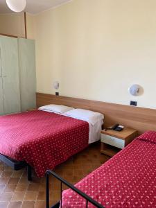 a hotel room with two beds and a table at Hotel Flamingo in Rimini