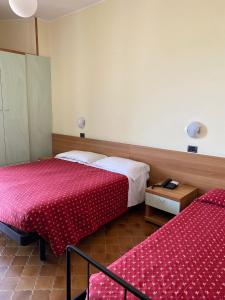 リミニにあるHotel Flamingoのベッド2台とテーブルが備わるホテルルームです。