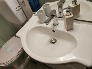 ein Badezimmer mit einem weißen Waschbecken und einem WC in der Unterkunft TIME KEEPER - SELF check in in Osijek