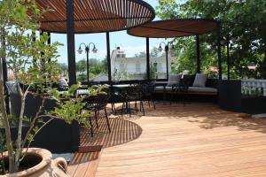eine Außenterrasse mit Tischen, Stühlen und Sonnenschirmen in der Unterkunft Zeus Hotel in Platamonas
