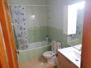 y baño con aseo, bañera y lavamanos. en Casa Gaia, en Las Playitas