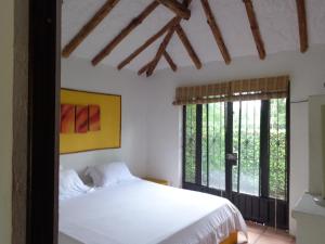 A bed or beds in a room at Hotel Campestre Arboretto