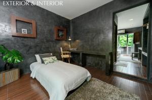 a bedroom with a bed and a desk and a mirror at Madison Hotel in Nakhon Si Thammarat