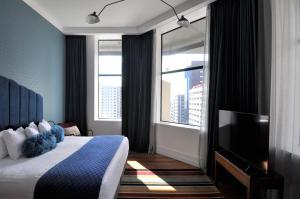 a hotel room with a bed and a television at Private apartments in a Landmark Heritage Building in Auckland