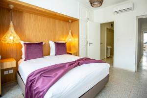 a bedroom with a large bed with purple sheets at Balima Minaret Suites in Rabat