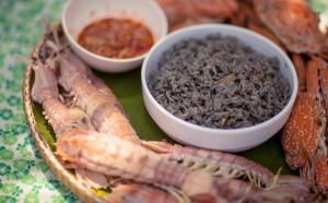 a plate of food with some lobsters and a bowl of food at Madison Hotel in Nakhon Si Thammarat