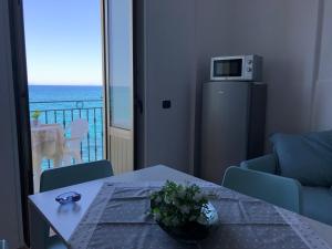 a living room with a table and a view of the ocean at La Casa Sulla Scogliera in Cefalù