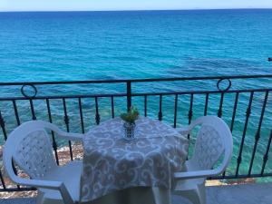 a table and chairs on a balcony with the ocean at La Casa Sulla Scogliera in Cefalù