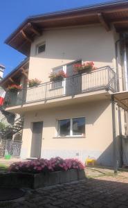 un bâtiment blanc avec des boîtes de fleurs sur les balcons dans l'établissement "La Bella della Cappuccina" Casa con Parcheggio Interno Gratuito, à Domodossola