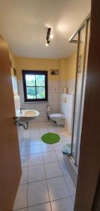 a bathroom with a sink and a toilet and a window at Ferienwohnung groß in Lütow
