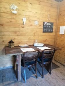 een houten tafel met stoelen in een kamer met houten wanden bij Agroturystyka Wiski 66 in Wiski
