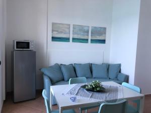 a living room with a blue couch and a table at La Casa Sulla Scogliera in Cefalù