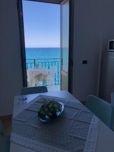 a table with a plate of food on it with a view of the ocean at La Casa Sulla Scogliera in Cefalù
