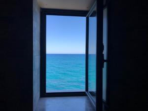 an open door with a view of the ocean at La Casa Sulla Scogliera in Cefalù