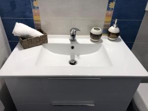a white bathroom sink with two soap dispensers on it at La Casa Sulla Scogliera in Cefalù