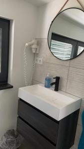 een badkamer met een witte wastafel en een spiegel bij Strandkieker 3 in Ueckermünde