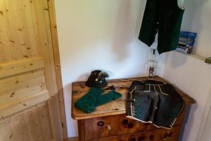 einem Holztisch mit Hut und grünen Handschuhen darauf in der Unterkunft Apartment Haider 1 in Obertraun
