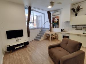 Il comprend un salon doté d'un canapé et d'une télévision. dans l'établissement Central Stay TLV Beachfront, à Tel Aviv