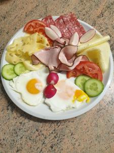 un piatto di prodotti per la colazione con uova, salsicce e verdure di Pension Verona a Nový Bor