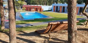 a bench sitting in front of a swimming pool at Mobility Friends Hostel in Barcelos
