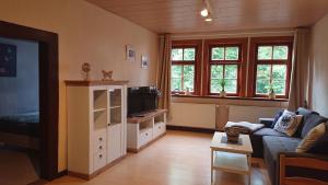 uma sala de estar com um sofá e uma televisão em Ferienwohnung zur Ratsklause em Arnstadt