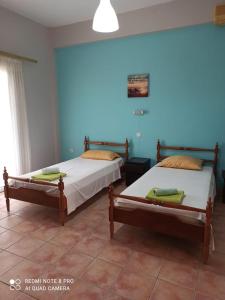 due letti in una stanza con pareti blu di Villa Sia a Dassia