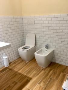 uma casa de banho branca com um WC e um bidé em Casa Maka' em Olbia