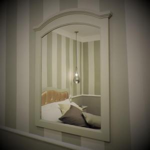 a mirror in a room with a bed and a lamp at Boutique Hotel Masolino in Panicale