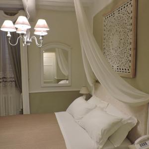 a bedroom with a bed and a mirror at Boutique Hotel Masolino in Panicale