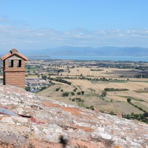 un pequeño edificio en la cima de una colina con un campo en Boutique Hotel Masolino, en Panicale