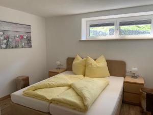 Un dormitorio con una cama con almohadas amarillas. en Appartements Wolfgang Auderer, en Jerzens