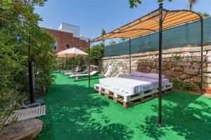 1 cama en un pabellón en un césped verde en Villa Lina en Marina Serra