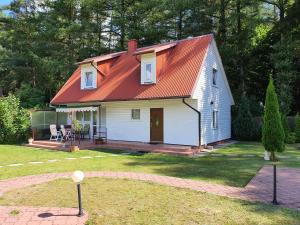 ein kleines weißes Haus mit orangefarbenem Dach in der Unterkunft Domek na Kaszubach in Bieszkowice