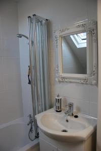 a bathroom with a sink and a shower with a mirror at Lovely 1 bed split level flat in Ramsgate in Kent