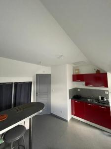 - une petite cuisine avec des placards rouges et un comptoir dans l'établissement Gîte dans le vignoble de Bourgueil, à Le Port Boulet