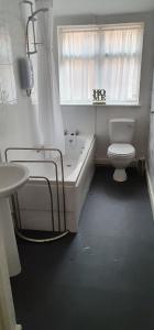 a bathroom with a tub and a toilet and a sink at Cruden Villa - Second Floor Apartment in Scarborough +5 photos