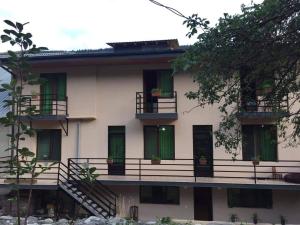 un edificio bianco con porte e balconi verdi di Lisaneli a Mestia