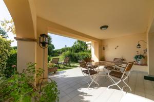 a patio with a wooden table and chairs at Residence Velas Garden Pool Suite in S'Agaro