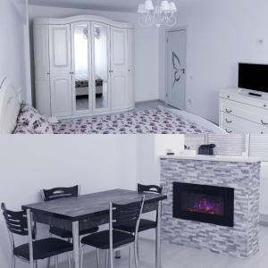 ein Wohnzimmer mit einem Tisch und einem Kamin in der Unterkunft White Apartament, Brăila in Brăila