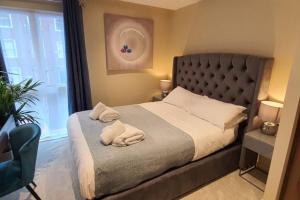 a bedroom with a bed with two towels on it at Luxury One Bedroom Apartment Within the City Walls in York