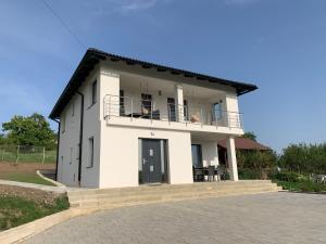 een wit gebouw met een balkon met twee personen erop bij Viktoria House in Odorheiu Secuiesc