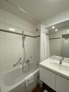 a bathroom with a shower and a tub and a sink at Aalst City Center Apartment in Aalst