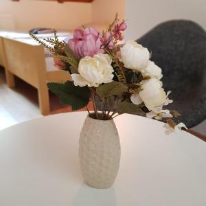 a vase filled with flowers sitting on a table at Studio apartman Ivana in Jajce