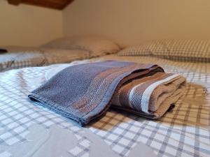 a blanket sitting on top of a bed at Studio apartman Ivana in Jajce