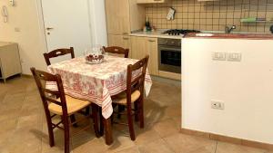 a kitchen with a table with chairs and a refrigerator at La Moretta in Fano
