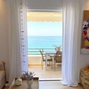 a living room with a view of the ocean through a door at Corfu, Glyfada, Sea la vie apartment in Glyfada