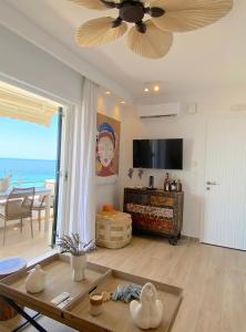 salon z wentylatorem sufitowym i widokiem na ocean w obiekcie Corfu, Glyfada, Sea la vie apartment w mieście Glifada
