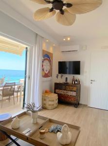 a living room with a ceiling fan and a view of the ocean at Corfu, Glyfada, Sea la vie apartment in Glyfada