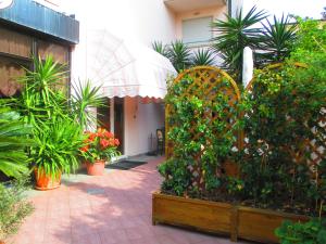 a garden with plants and trees and a building at Hotel Prestige in Lido di Camaiore