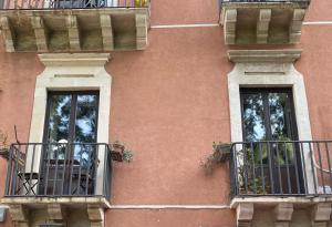 two windows on the side of a building with balconies at Duomo Treehouse in Catania